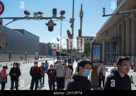 I pedoni camminano sotto le telecamere CCTV in via Wangfujing a Pechino, Cina. 16 ottobre 2021 Foto Stock