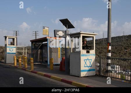 I soldati israeliani si trovano dietro blocchi di cemento in una stazione degli autobus situata lungo l'autostrada 5, che collega la costa mediterranea con gli insediamenti israeliani nella Cisgiordania settentrionale, vicino all'insediamento israeliano di Ariel il 14 ottobre 2021 in Cisgiordania, Israele. Attualmente, la maggior parte della Cisgiordania è amministrata da Israele anche se il 42% di essa è sotto vari gradi di autonomia da parte dell'autorità palestinese gestita da Fatah. Foto Stock