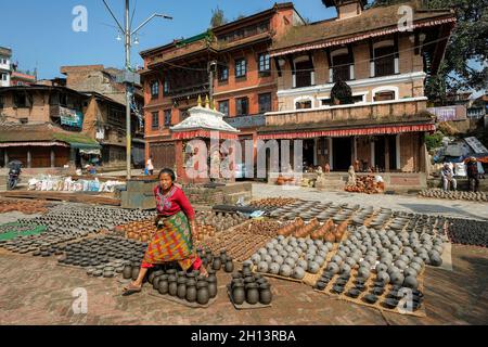 Bhaktapur, Nepal - Ottobre 2021: Una donna che vende ceramiche in Piazza delle ceramiche a Bhaktapur il 10 Ottobre 2021 nella Valle di Kathmandu, Nepal. Foto Stock