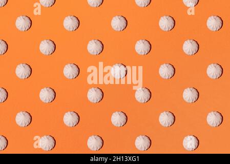 motivo marshmallow su sfondo arancione. Disposizione piatta, vista dall'alto concetto minimale. Foto Stock