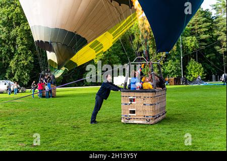 Vilnius, Lituania - 14 settembre 2021: Uomo del personale di terra che tiene il cesto con pilota e passeggeri all'interno prima del lancio di mongolfiere a Foto Stock