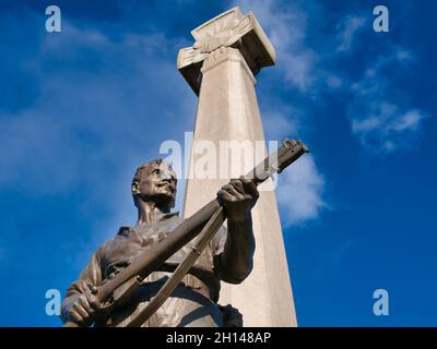 La figura in bronzo di un soldato e fucile con croce runica dietro al Port Sunlight War Memorial di Sir William Goscombe John. Foto Stock