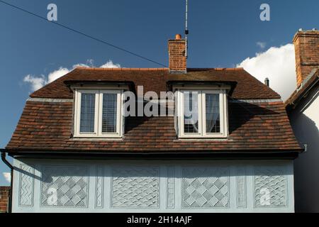 Primo piano le finestre moderne di prolungamento del tetto su casa blu con decorazioni sul muro a Saffron Walden, Inghilterra Foto Stock