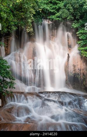 Bella cascata Sai Yok noi che scorre su calcare nella foresta pluviale tropicale al parco nazionale, Sai Yok, Kanchanaburi, Thailandia Foto Stock