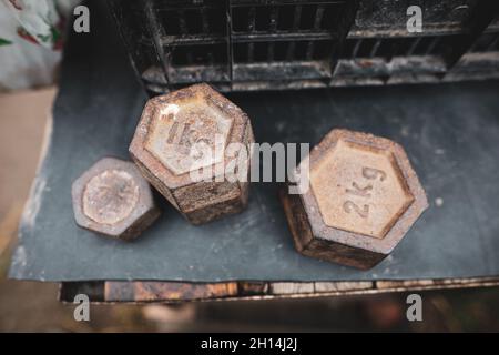 Profondità di campo poco profonda (fuoco selettivo) immagine con vecchi pesi di scala sulla tabella di un contadino rumeno che vende verdure dal suo giardino in una campagna Foto Stock