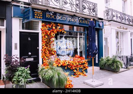 Cococo Chocolates Belgravia, un negozio di cioccolato su Motcomb Street, Londra, Inghilterra, Halloween decorazione finestra e girasoli 2021 Foto Stock