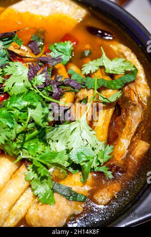 Un delizioso piatto guangxi cinese speciale, lumache e piedi d'anatra in vaso di argilla Foto Stock