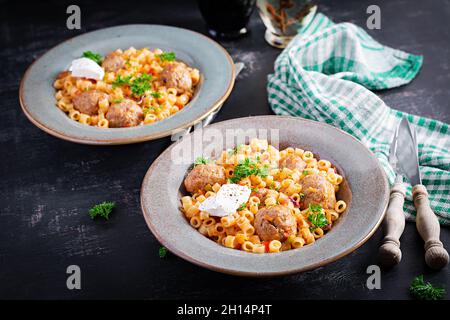 Ditalini tradizionale italiana con polpette in salsa di pomodoro e verdure in ciotola. Ditalini pasta e polpette di manzo con salsa di pomodoro marinara. Foto Stock