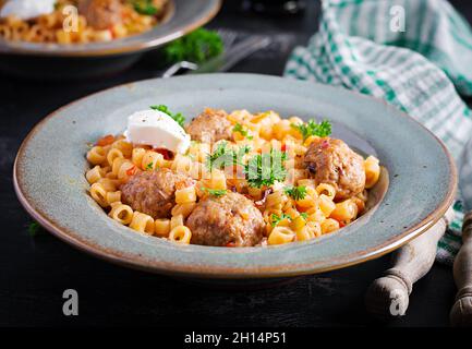 Ditalini tradizionale italiana con polpette in salsa di pomodoro e verdure in ciotola. Ditalini pasta e polpette di manzo con salsa di pomodoro marinara. Foto Stock