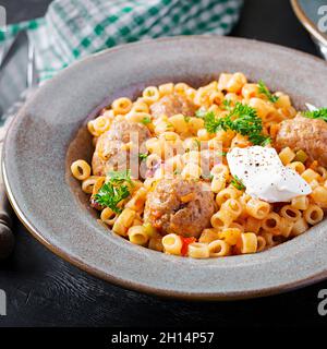 Ditalini tradizionale italiana con polpette in salsa di pomodoro e verdure in ciotola. Ditalini pasta e polpette di manzo con salsa di pomodoro marinara. Foto Stock