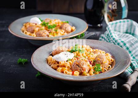 Ditalini tradizionale italiana con polpette in salsa di pomodoro e verdure in ciotola. Ditalini pasta e polpette di manzo con salsa di pomodoro marinara. Foto Stock