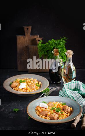 Ditalini tradizionale italiana con polpette in salsa di pomodoro e verdure in ciotola. Ditalini pasta e polpette di manzo con salsa di pomodoro marinara. Foto Stock