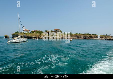 Isola di Sant'Anastasia nella baia di Burgas, Mar Nero, Bulgaria. Torre faro e vecchi edifici in legno sulla costa rocciosa. Foto Stock