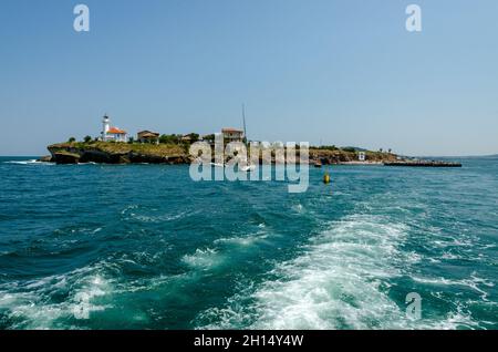 Isola di Sant'Anastasia nella baia di Burgas, Mar Nero, Bulgaria. Torre faro e vecchi edifici in legno sulla costa rocciosa. Foto Stock