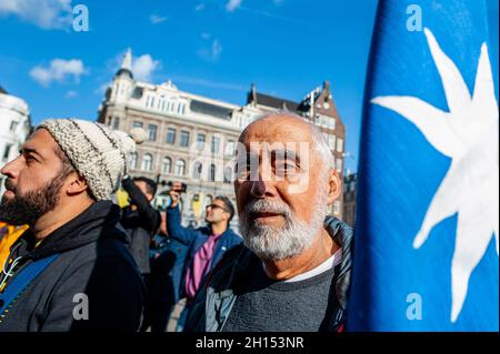 Durante la manifestazione si vede un uomo cileno che detiene una grande bandiera cilena. Nel secondo anniversario dell'epidemia sociale cilena, diverse organizzazioni sociali, politiche e per i diritti umani con sede a livello europeo si sono riunite per chiedere verità, giustizia, riparazione e garanzie di non ripetizione per le violazioni sistematiche dei diritti umani commesse da funzionari di polizia cileni, appoggiati dal presidente di seduta del Cile, Sebastian Piñera. Ad Amsterdam, la comunità cilena ha organizzato una manifestazione accompagnata da spettacoli e musica cilena nel centro della città. (Foto di Ana Fernandez/SOPA Foto Stock