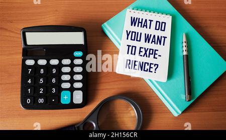 CHE COSA VOLETE sperimentare , testo su blocco note con cancelleria Foto Stock
