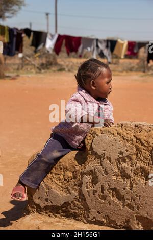 Single African girl, bambino in un villaggio in Botswana in attesa nel cortile, Foto Stock