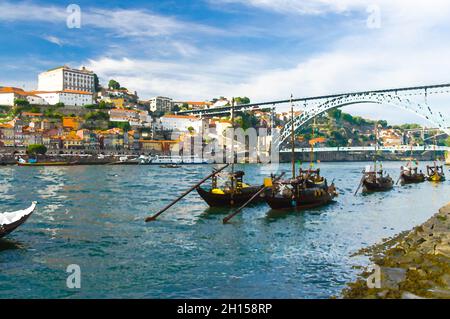 Disegno acquerello di case colorate del centro storico di Porto, barche in legno sul fiume Douro da vicino, vista città vecchia di Porto, un gruppo di barche a vela sotto bri Foto Stock