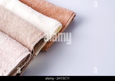 Asciugamani in cotone di colore pastello su sfondo chiaro. Sfondo per la dimostrazione di cosmetici per corpo, capelli, cura del viso, sfondo selettivo, copyin Foto Stock