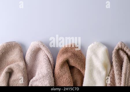 Asciugamani in cotone di colore pastello su sfondo chiaro. Sfondo per la dimostrazione di cosmetici per corpo, capelli, cura del viso, sfondo selettivo, copyin Foto Stock
