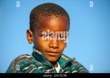 Bambini africani nel cortile del villaggio in Botswana, zona rurale, giocando nel cortile, cielo blu sfondo Foto Stock