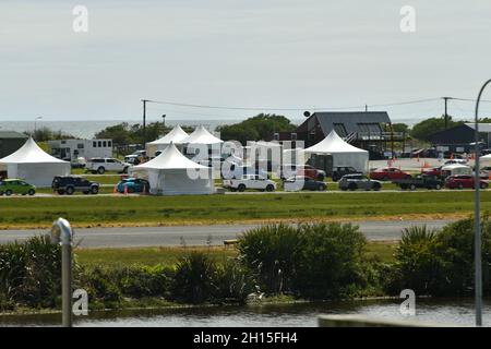 GREYMOUTH, NUOVA ZELANDA, 16 OTTOBRE 2021:Heat haze parzialmente oscura un'immagine della gente a Greymouth allineato in su all'aeroporto per le vaccinazioni di massa di Covid il Super Sabato. 130,000 sono stati vaccinati a livello nazionale. Foto Stock