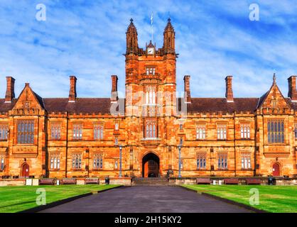 Torre dell'Orologio dello storico edificio in pietra arenaria del quartiere educativo della Citta' di Sydney con prati e facciate gotiche. Foto Stock