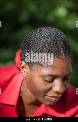 Giovane donna africana di Motswana, in piedi nel giardino verde sfondo vegetazione Foto Stock