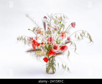 Bouquet misto di fiori selvatici e erbe in un vaso di vetro. Papavero. Foto Stock