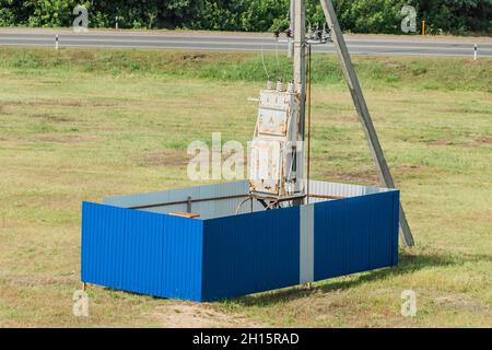 Vecchia scatola elettrica o pannello su un palo, controllo di apparecchiature elettriche. Foto Stock