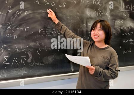 Studente cinese alla lavagna in una classe matematica MR - modello rilasciato Foto Stock