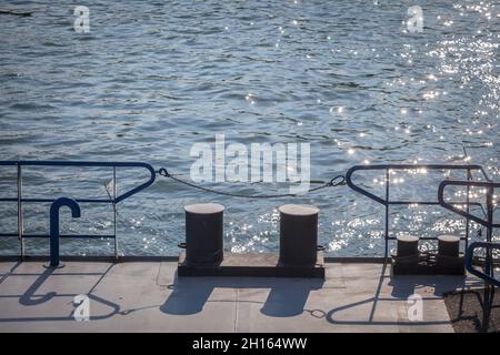 Sfocatura selettiva su una barca che ormeggia il bullard su un molo, un molo di molo vicino a un fiume vicino al mare, utilizzato per ancorare e ormeggio navi al suolo. Immagine di Foto Stock