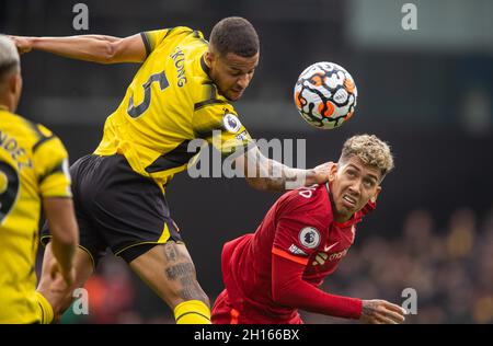 Watford. 17 ottobre 2021. William Trosst-Ekong (C) di Watford sfida per un header con Roberto Firmino (R) di Liverpool durante la partita della Premier League tra Watford e Liverpool a Watford, in Gran Bretagna, il 16 ottobre 2021. Credit: Xinhua/Alamy Live News Foto Stock