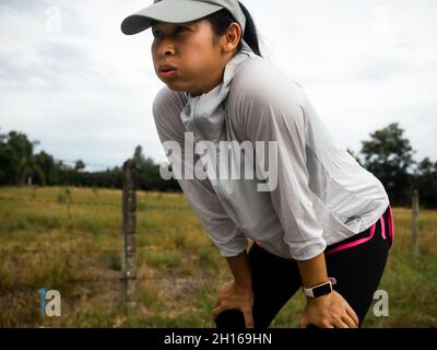 Le donne stanche si riposano dopo aver percorso un percorso molto lungo la strada durante l'allenamento mattutino per il fitness. Concetto di stile di vita sano. Atleta che corre ex Foto Stock