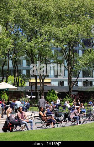 I visitatori si rilassano sul prato del Bryant Park nel centro di Manhattan.New York City.USA Foto Stock