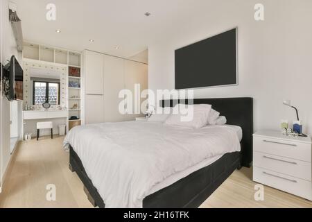 Comodo letto posto vicino comodino con pianta in elegante camera da letto  Foto stock - Alamy