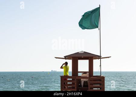 Vista laterale del binocolo sulla torre di avvistamento in legno mentre si sorpassa la sicurezza in mare Foto Stock