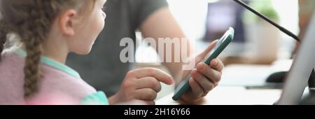 Il programmatore maschile mostra la bambina gioco su smartphone per il test Foto Stock