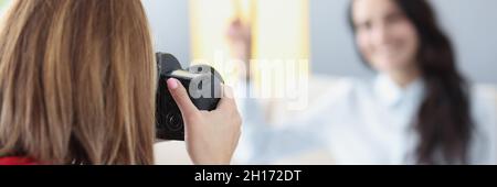 Donna fotografo scatta foto di ragazza sul divano Foto Stock