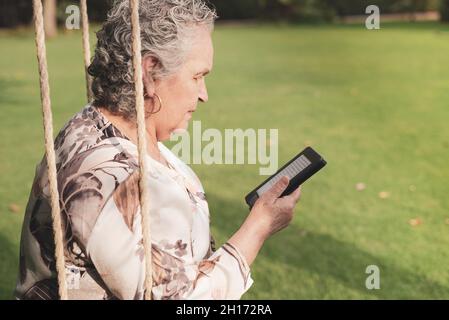Vista subacquea di una femmina rilassata irriconoscibile che giace sulla superficie dell'acqua in piscina e godendo del tempo soleggiato durante le vacanze estive in resort Foto Stock