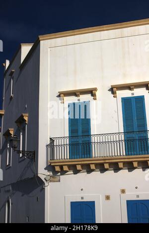 Nel centro storico di Gallipoli, la facciata bianca di una casa riflette la luce di un bel sole di ottobre (Puglia, Italia) Foto Stock