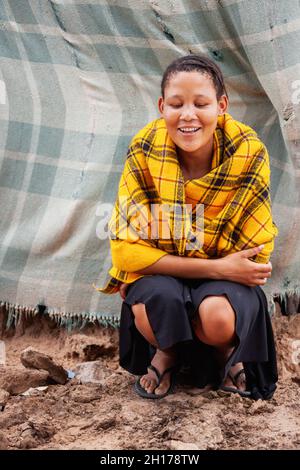 giovane basarwa coperto con coperta gialla Foto Stock