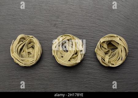 Tagliatelle o nido spinaci pasta isolata su sfondo bianco. Il file contiene il percorso di ritaglio. Pasta tradizionale italiana. Vista dall'alto. Foto Stock