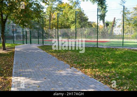 Scuola di calcio stadio. Campo da calcio vuoto dietro la recinzione di ferro Foto Stock