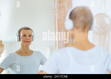 Donna sportiva anziana ammirando se stessa nello specchio. Foto Stock
