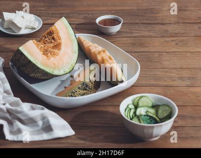 Meloni freschi affettati su tavola di legno. Spazio libero per il testo. Vista dall'alto. Melone affettato di meloni giapponesi, melone al miele o cantalupe Cucumis melo su legno t Foto Stock