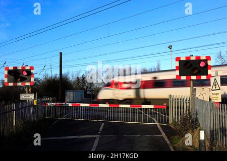 Treno Azuma che passa luci rosse a un incrocio senza equipaggio, East Coast Main Line Railway, Peterborough, Cambridgeshire, Inghilterra, Regno Unito Foto Stock