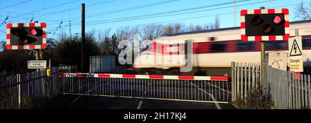 Treno Azuma che passa luci rosse a un incrocio senza equipaggio, East Coast Main Line Railway, Peterborough, Cambridgeshire, Inghilterra, Regno Unito Foto Stock