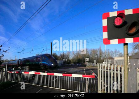 Treni di carena treno Paragon passando luci rosse ad un varco di livello senza equipaggio, East Coast Main Line Railway; Peterborough, Cambridgeshire, Inghilterra Foto Stock