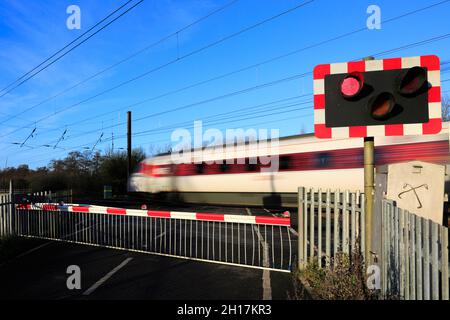 Treno Azuma che passa luci rosse a un incrocio senza equipaggio, East Coast Main Line Railway, Peterborough, Cambridgeshire, Inghilterra, Regno Unito Foto Stock